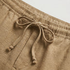 Close-up of the knotted drawstring cord on khaki linen shorts