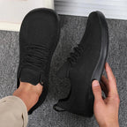 Front angle of light blue sneaker on foot beside bare foot, white sole visible