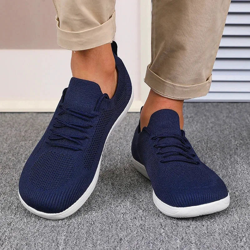 Side view of dark grey sneaker showing white outsole and ribbed tread pattern