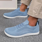 Side profile of light blue knit sneaker on foot, showing elastic lace loops and knit panels
