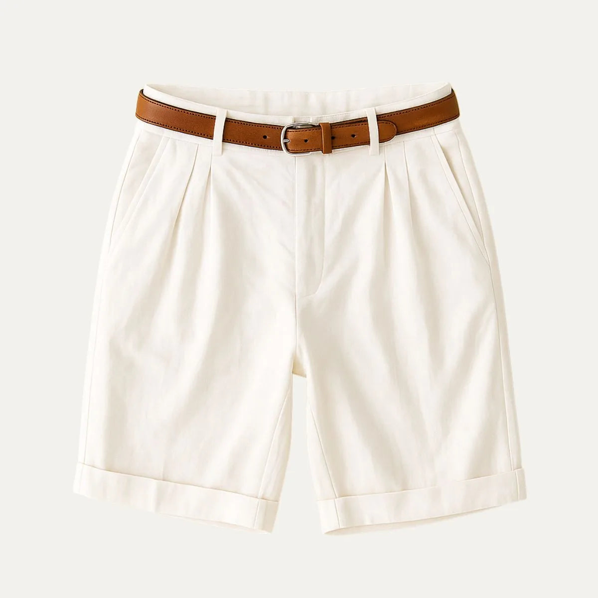 Flat lay of cream pleated chino shorts with turn-up cuffs and a brown leather belt attached