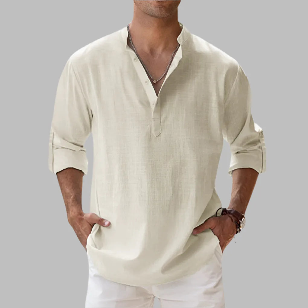Beige linen shirt with buttoned collar and rolled sleeves, worn untucked over white trousers