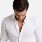 Close-up of white shirt collar and placket, worn open at the neck with cuffs rolled