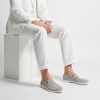 Angled view of a beige suede loafer highlighting the soft rounded toe and stitched vamp detail