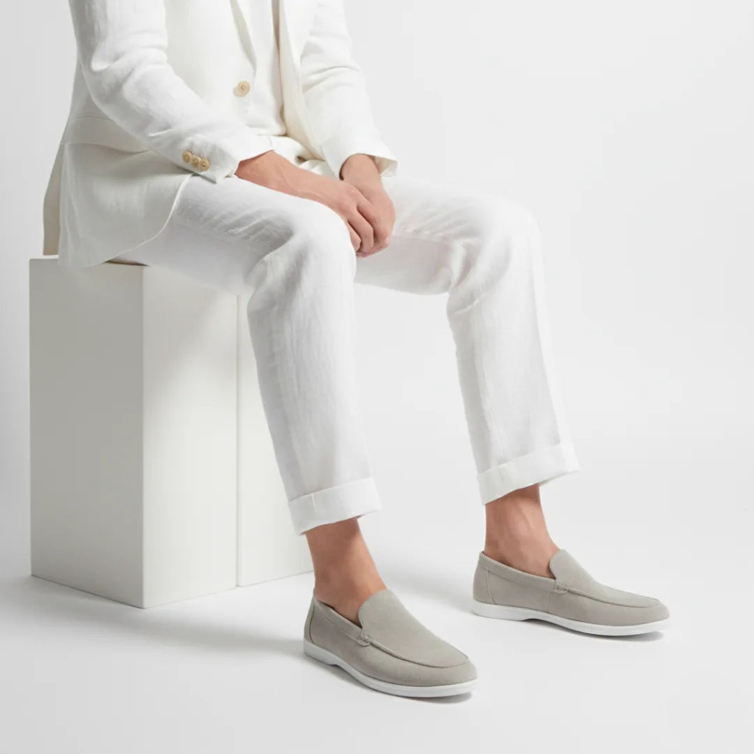 Angled view of a beige suede loafer highlighting the soft rounded toe and stitched vamp detail