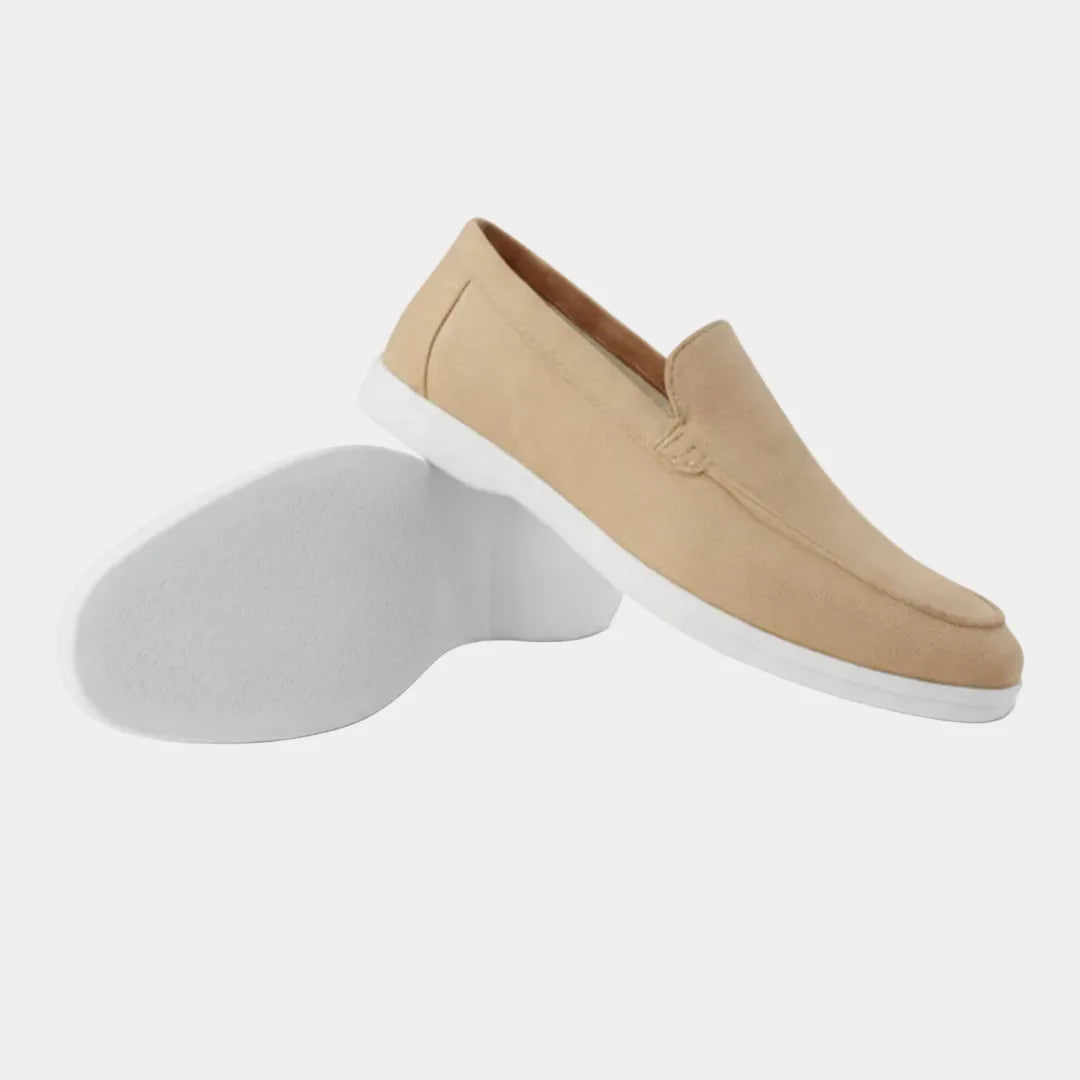 Close-up of a dark brown suede loafer's topline and heel, showing the slip-on construction