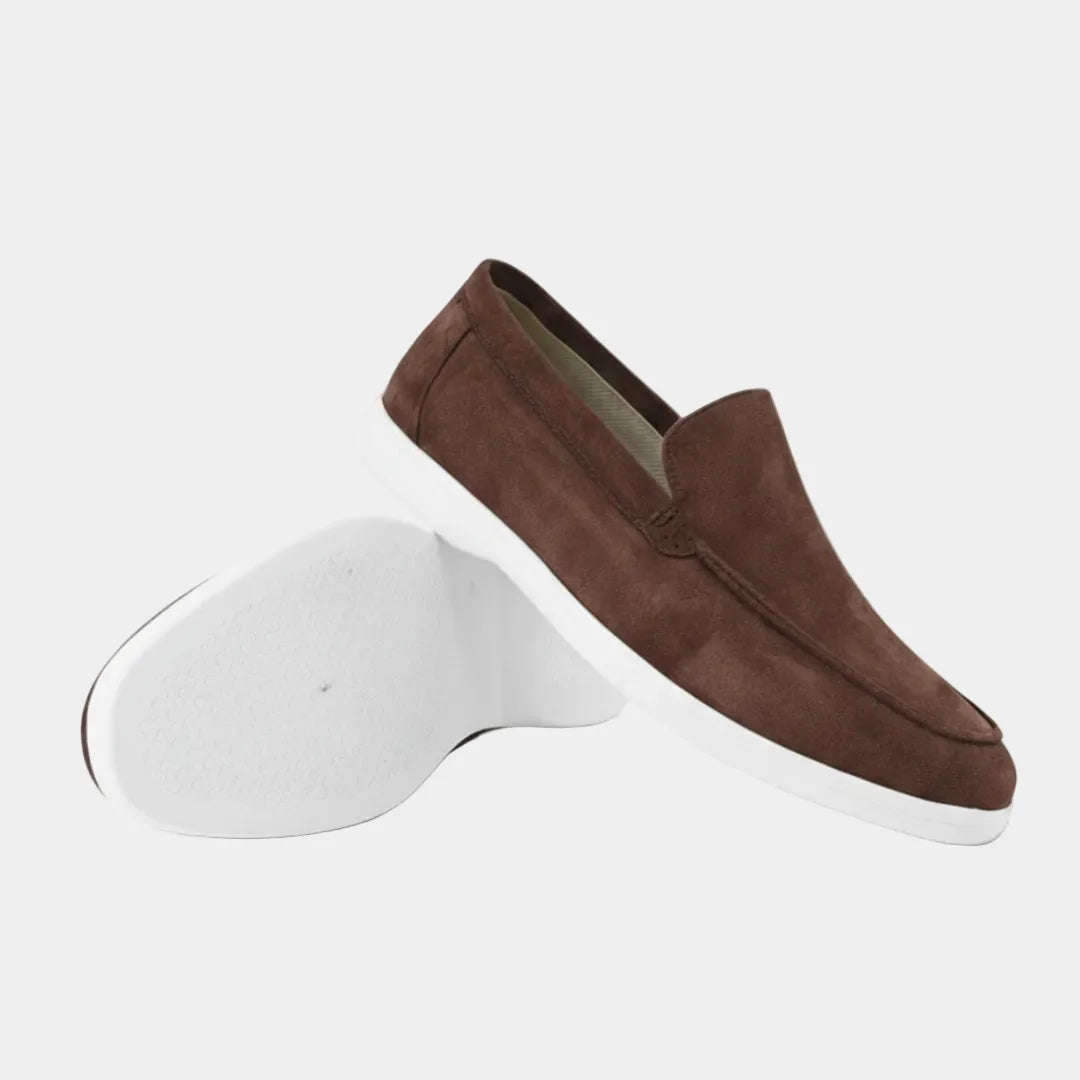 Brown suede loafer shown in profile beside its pair, highlighting the apron seam and white sole