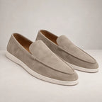 Close-up of dark brown suede loafer showing stitched toe seam and tonal knot detail