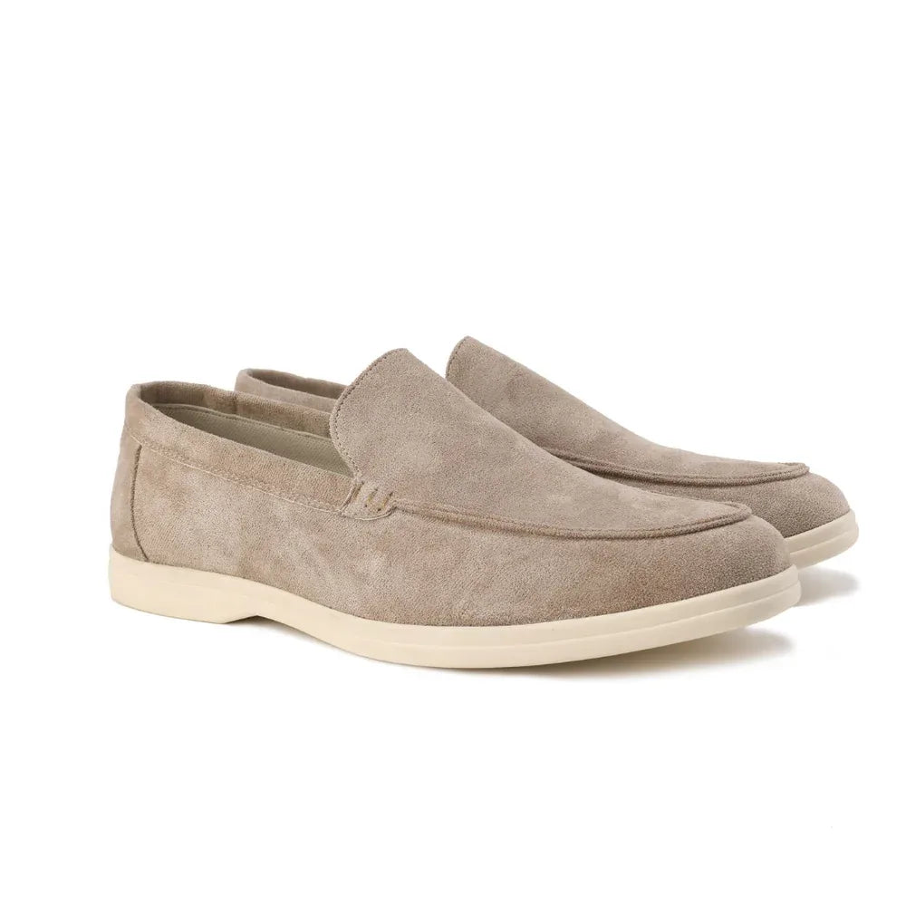 Side profile of beige suede loafers on a white background showing the clean slip-on silhouette