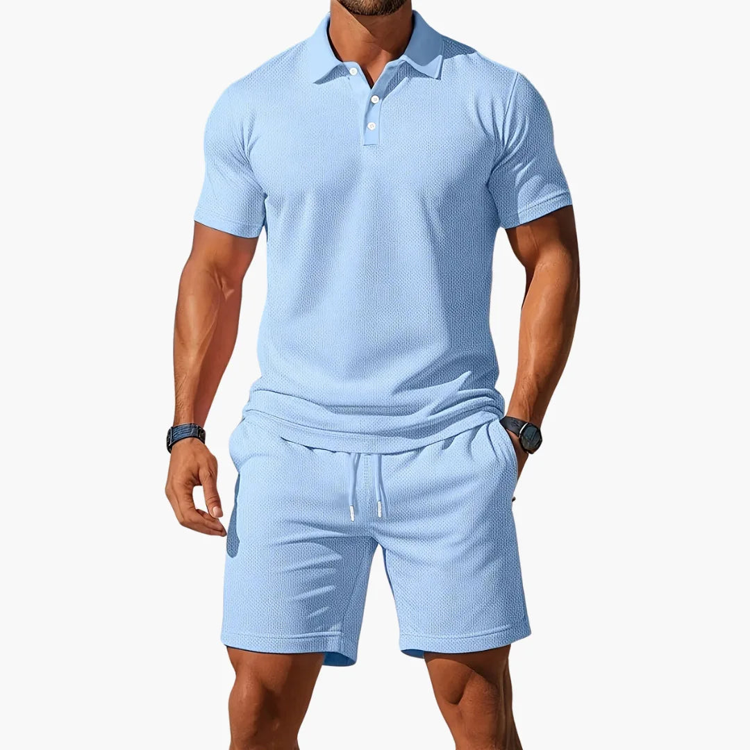 Man wearing a light blue textured polo and matching drawstring shorts set, front view against a plain backdrop.