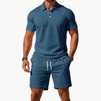 Steel blue polo shirt with contrast collar worn with matching drawstring shorts, front-facing studio shot.