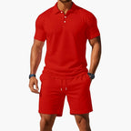 Red polo and shorts co-ord set with white button placket, shown on a model from the chest down.