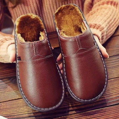 Brown leather slipper pair showing stitched seam detail and soft fleece interior lining.