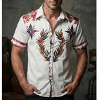 Close-up front view of a white short-sleeve shirt with bold red, navy and gold western floral embroidery down the placket