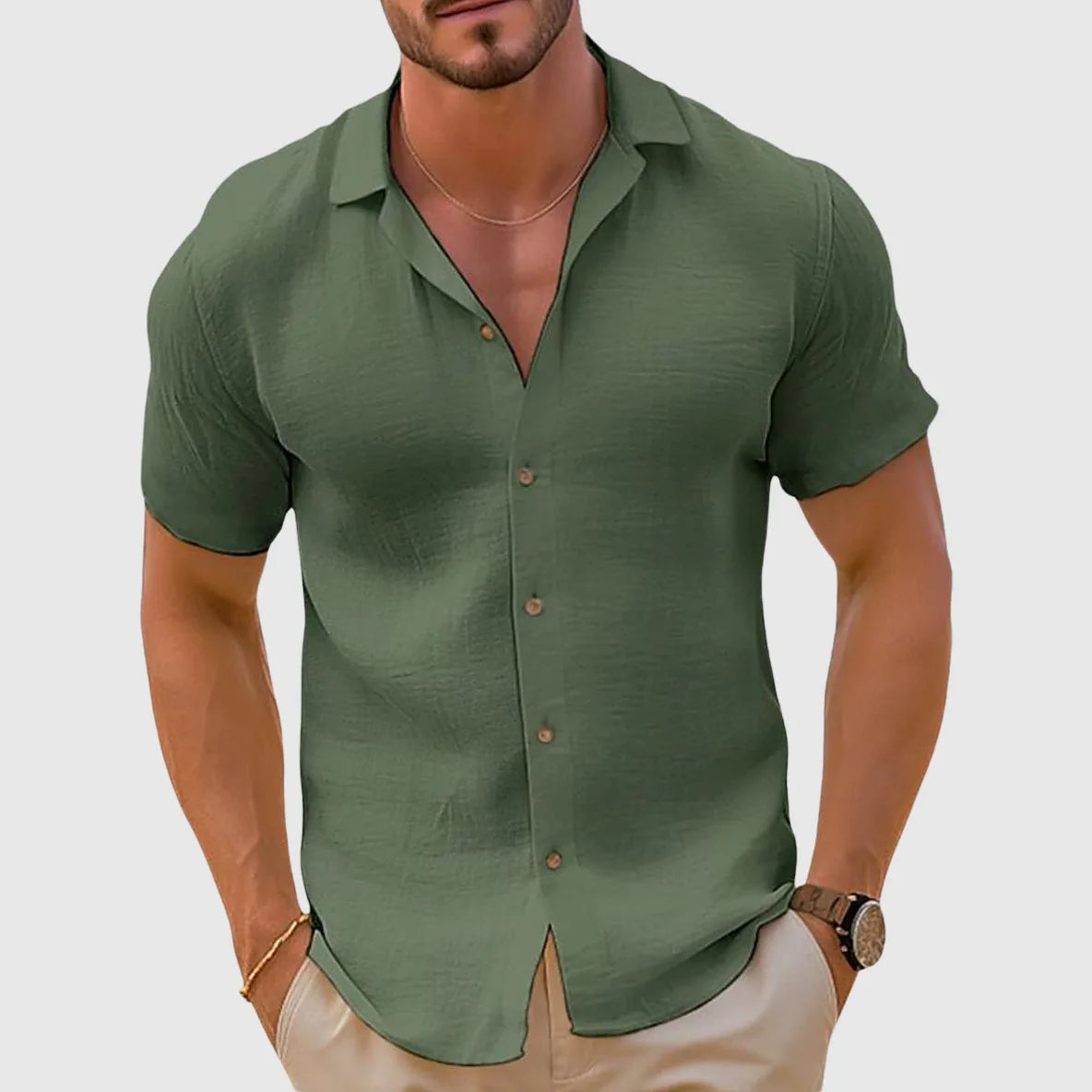 Olive green woven short sleeve button shirt with camp collar, paired with beige trousers
