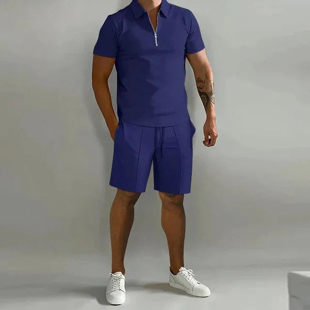 Royal blue zip-collar polo shirt and matching shorts outfit, full-length front view with white sneakers