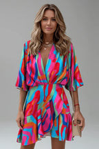 Model wearing a multicoloured abstract swirl print wrap dress with a deep V neckline and handbag