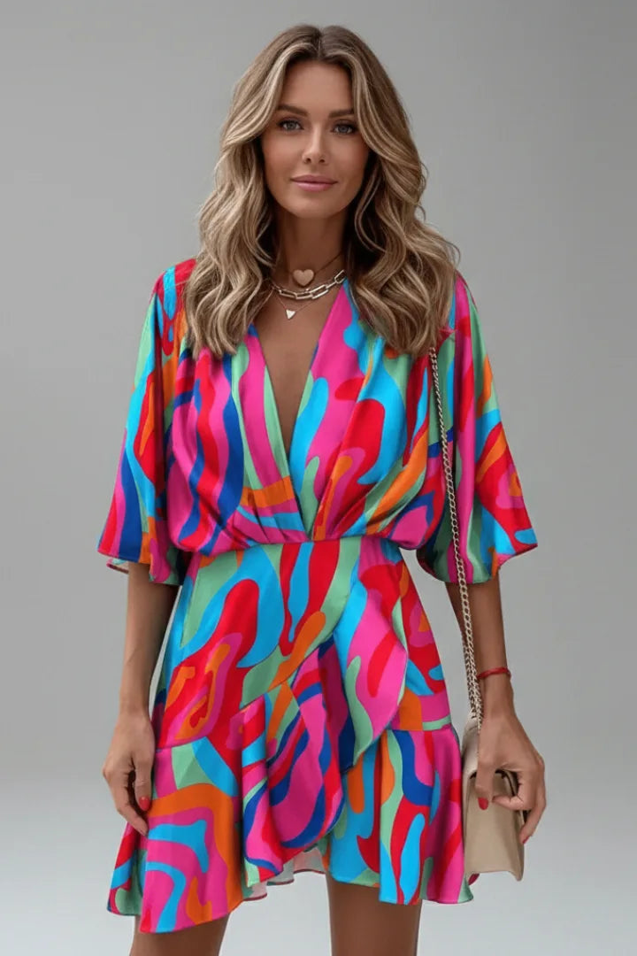Model wearing a multicoloured abstract swirl print wrap dress with a deep V neckline and handbag
