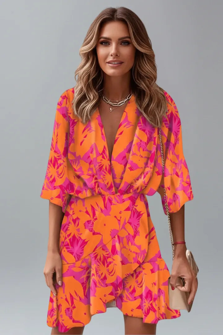 Model wearing an orange and pink floral print wrap mini dress with a deep V front