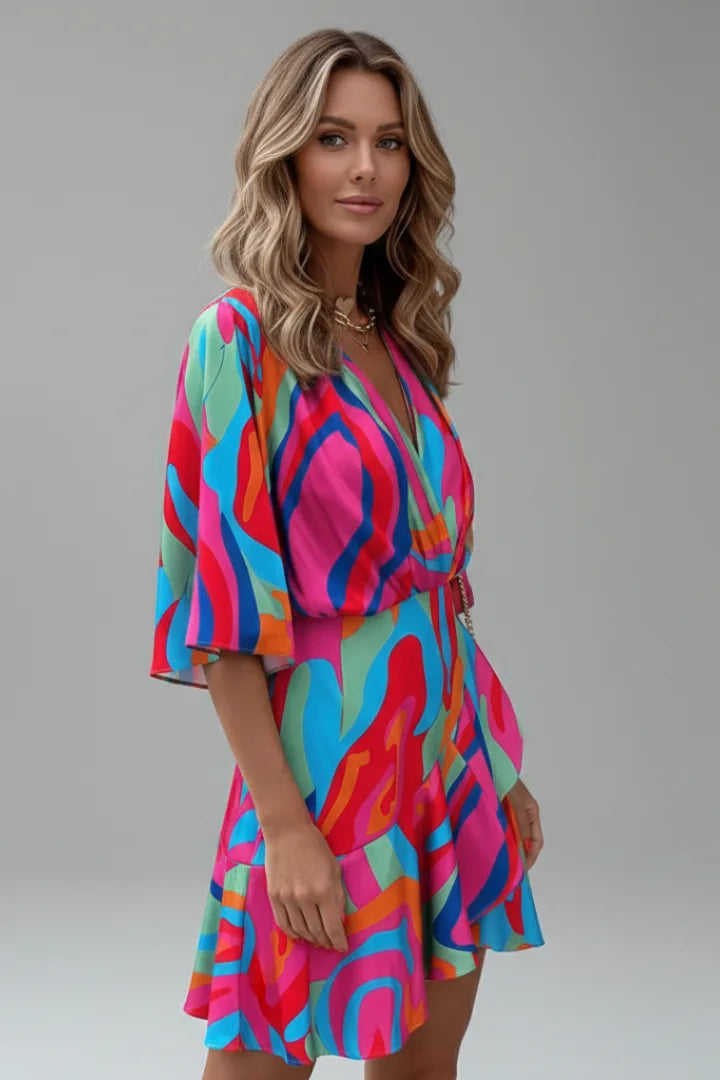 Side view of a model wearing a multicoloured swirl print wrap dress showing the tie waist detail