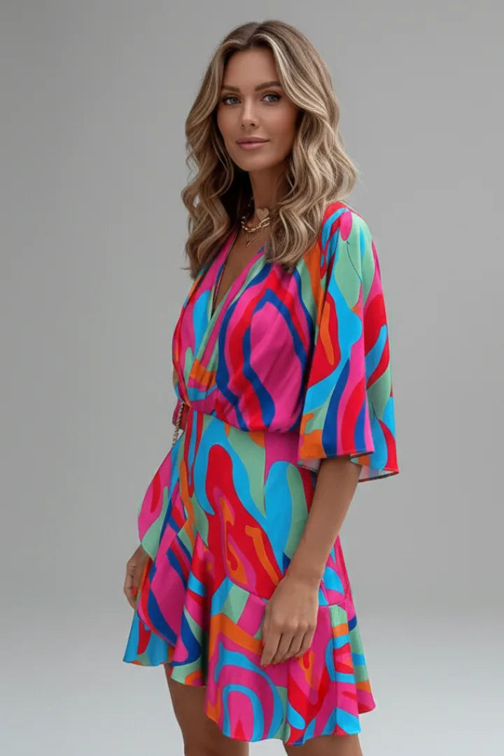 Side profile of a model in a multicoloured abstract print mini dress highlighting the flared sleeve