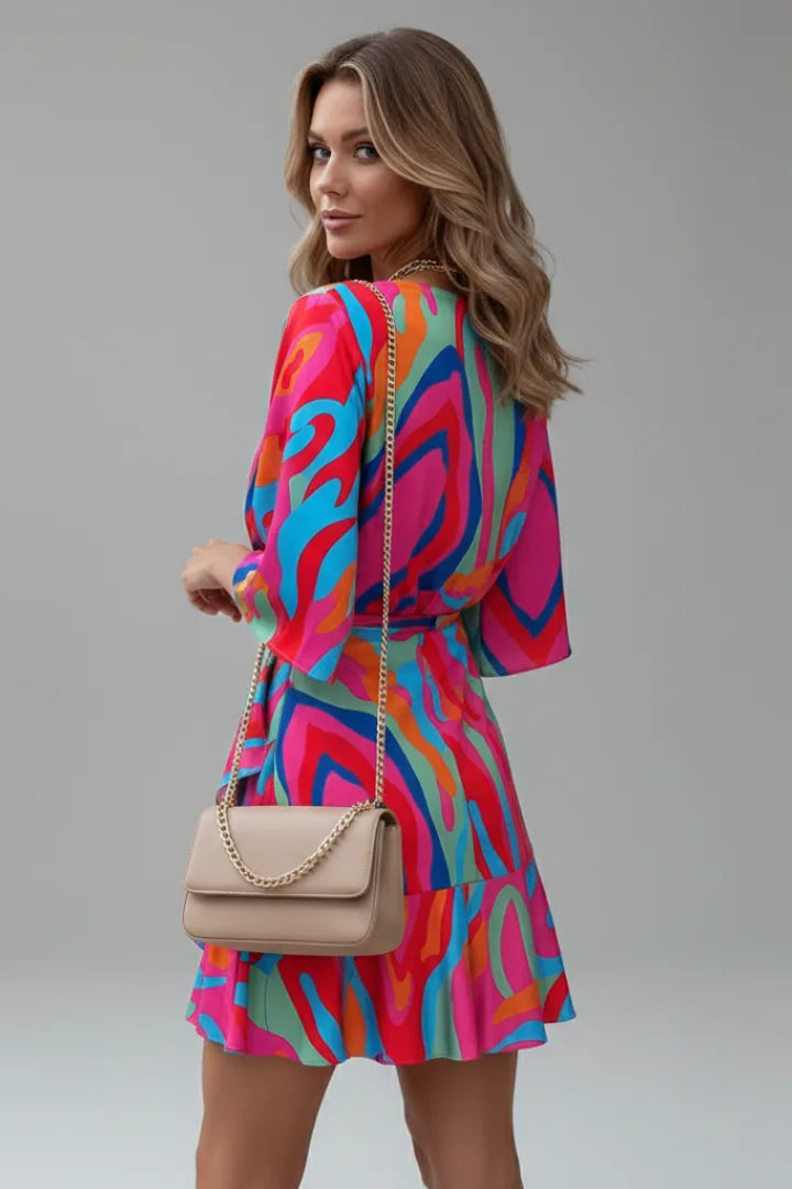 Close side view of the multicoloured wrap dress showing the ruffled asymmetric hemline