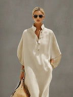 Close-up front view showing the mandarin collar, button neckline and loose dolman sleeve of the oatmeal linen dress