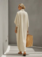Back view of the oatmeal linen dress showing the relaxed kaftan-style silhouette and dolman sleeve drape