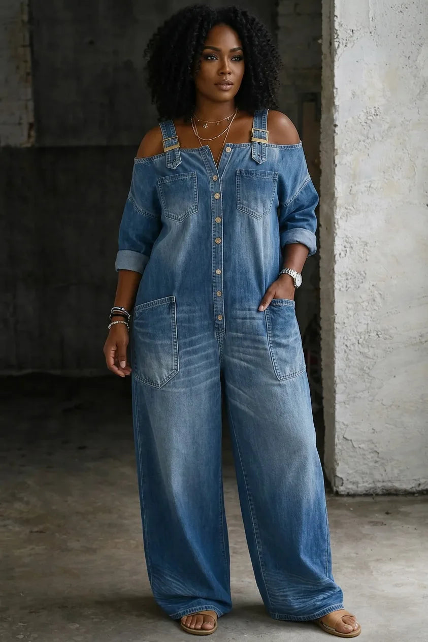 Off-shoulder denim jumpsuit in medium wash with button front, chest pockets, wide leg and tan buckle straps, worn with sandals