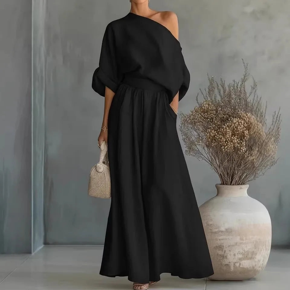 Black one-shoulder maxi set shown close up, highlighting the relaxed batwing sleeve and cinched waist detail