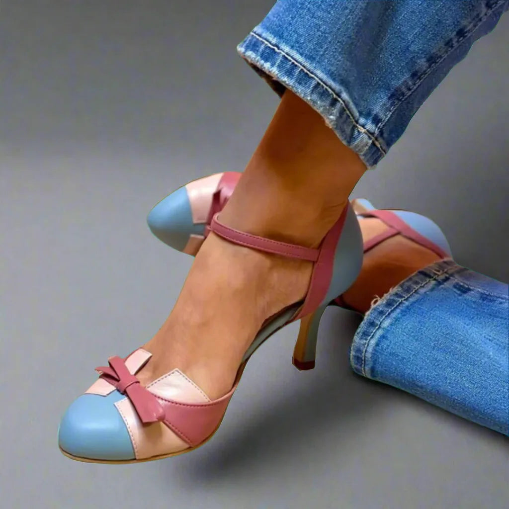 Close-up of colourblock heels in powder blue, dusty pink and nude leather with a bow detail, worn with cuffed jeans.