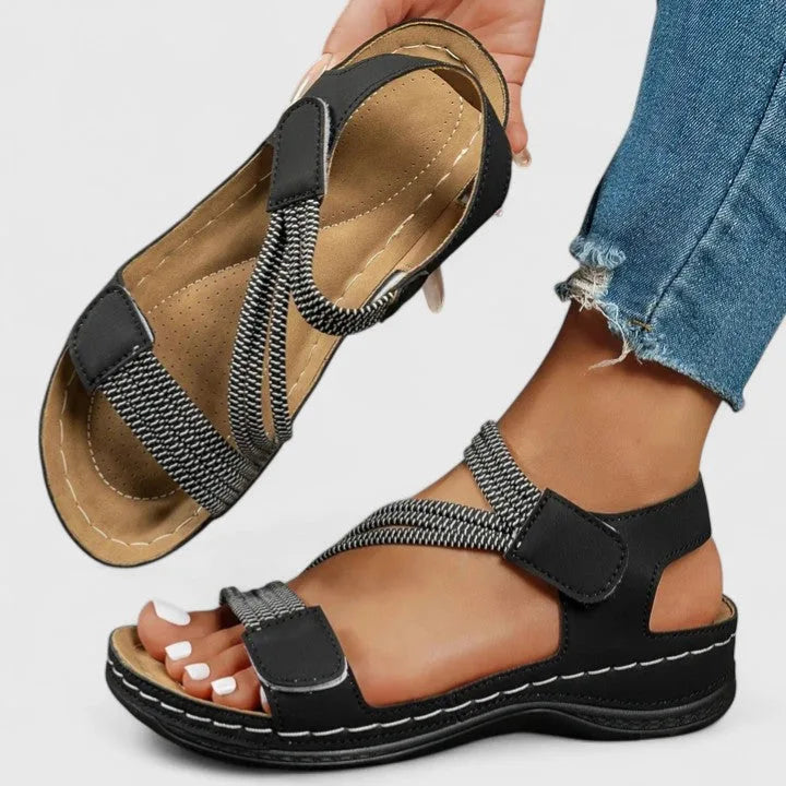 Pink sandal pair on feet from front showing matching crisscross strap pattern