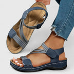 Rear view of white sandal pair worn showing heel strap and stitched cushioned footbed