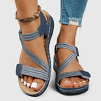 Blue and white woven strap sandal worn on feet with crossover front straps