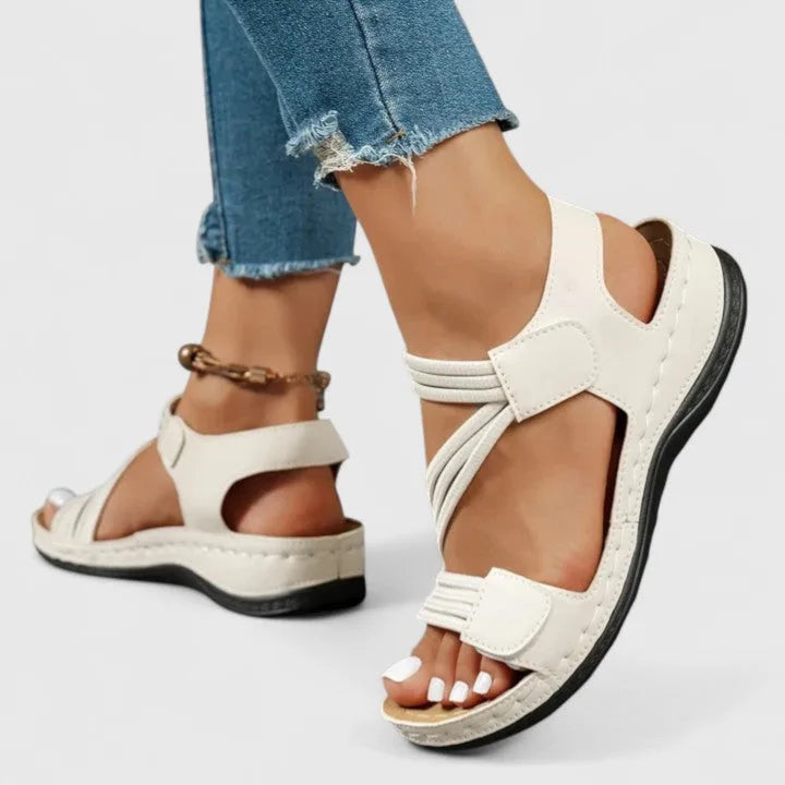 Back angle of white sandal worn showing heel cutout and ankle strap fastening