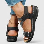 Close up of pink sandal on foot highlighting crisscross straps over the instep