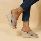 Khaki suede crisscross wedge sandals shown from behind, highlighting the woven wedge heel and cushioned footbed
