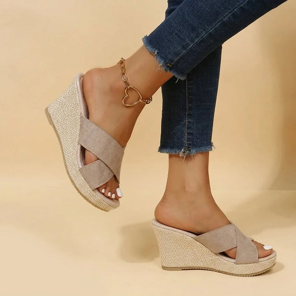 Khaki suede crisscross wedge sandals shown from behind, highlighting the woven wedge heel and cushioned footbed