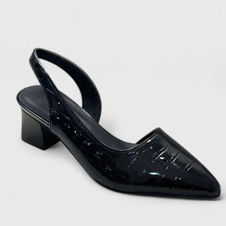 Side profile of a black croc-embossed patent slingback pump with pointed toe and low block heel on a white background
