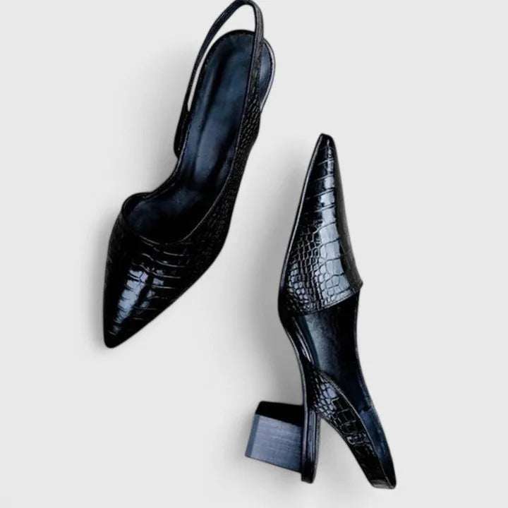 Overhead view of a matching pair of black croc-embossed slingback heels showing the pointed toe and block heel from above