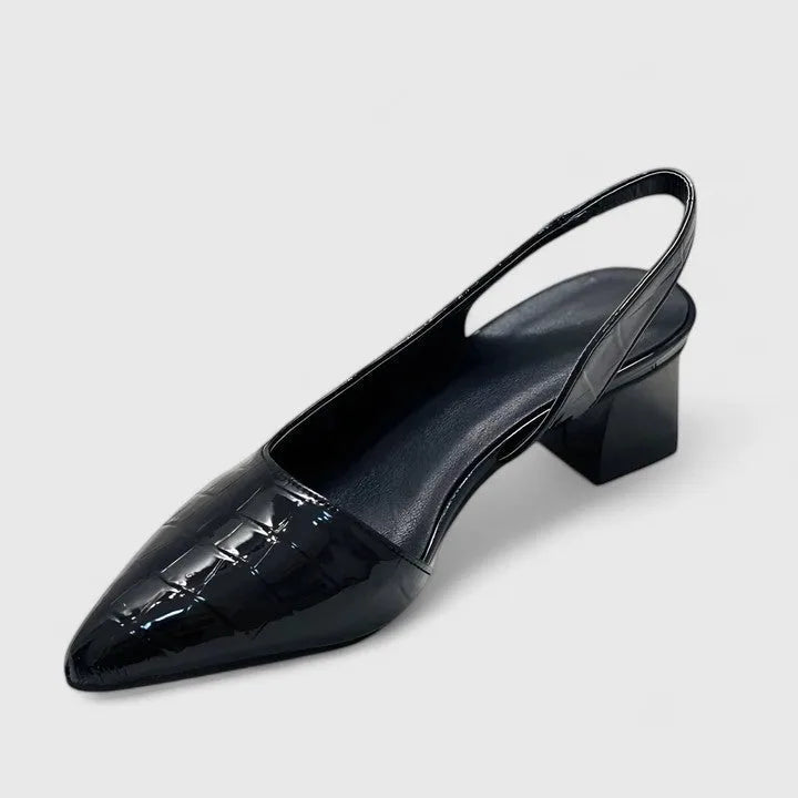 Angled rear view of a black croc-embossed slingback heel highlighting the block heel, sling strap and glossy finish