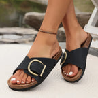 Close-up side view of blush pink sandals worn together, highlighting the crossover strap and brass buckle hardware