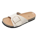 Overhead close-up of taupe crossover sandals on feet, showing buckle detail and ribbed cork sole edge from above