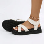 Side and sole view of cream white platform sandals showing the ribbed black tread and buckle ankle strap