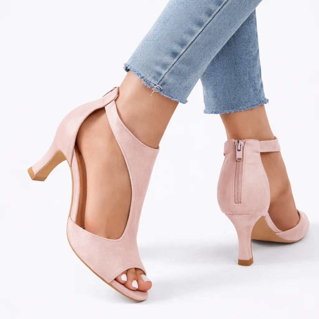 Pink suede cut-out heeled sandals shown from the side with visible zip closure at the back of the ankle