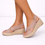 Light brown espadrille sandal with adjustable ankle buckle, side profile showing the crossover vamp and wedge sole.