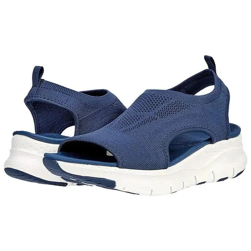 Pair of navy blue knit slip-on sandals with chunky white platform sole and cut-out side detail