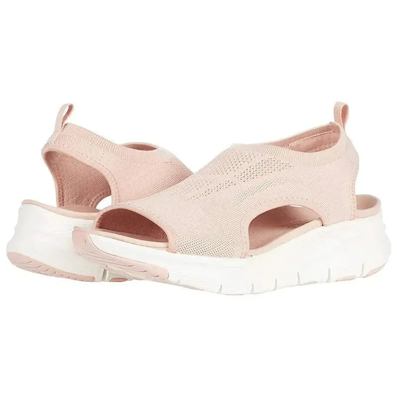 Blush pink knit sandals with shaped footbed and thick white wedge sole, side cut-out visible