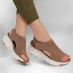 Woman wearing tan brown knit sandals with leggings, front angle showing open toe and platform sole
