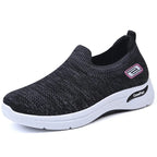 Side view of black knit slip-on sneaker with pink and white logo detail and white contrast sole